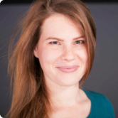 A woman with long hair is smiling for the camera.